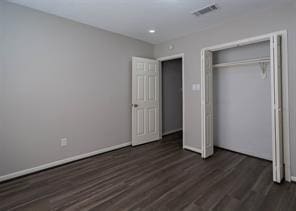 unfurnished bedroom with a closet, recessed lighting, baseboards, dark wood finished floors, and visible vents