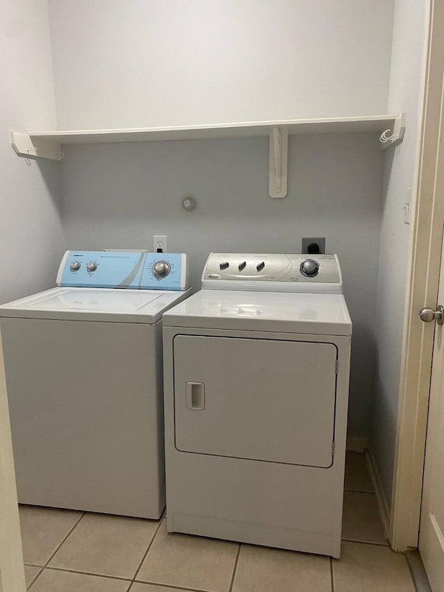 washroom featuring light tile patterned floors, laundry area, and washer and dryer