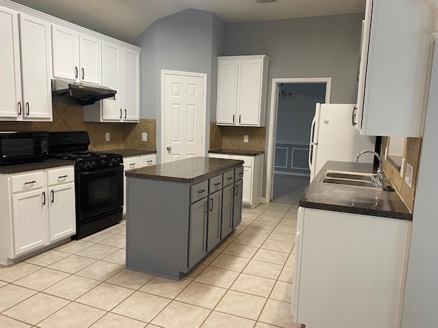 kitchen with a sink, black appliances, under cabinet range hood, light tile patterned floors, and dark countertops