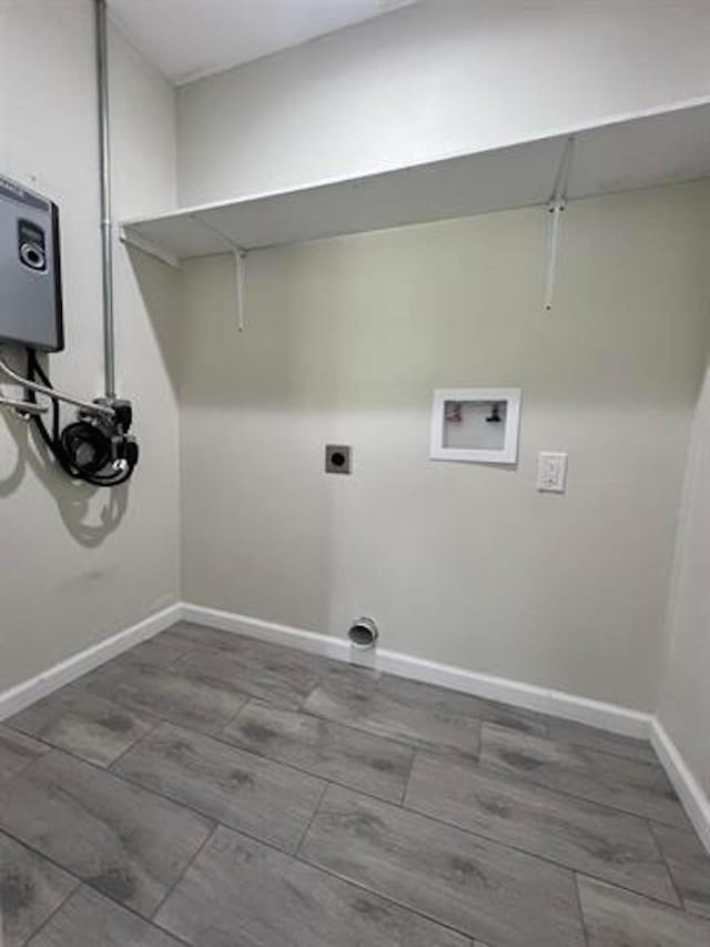 clothes washing area with hookup for a washing machine, electric dryer hookup, and baseboards