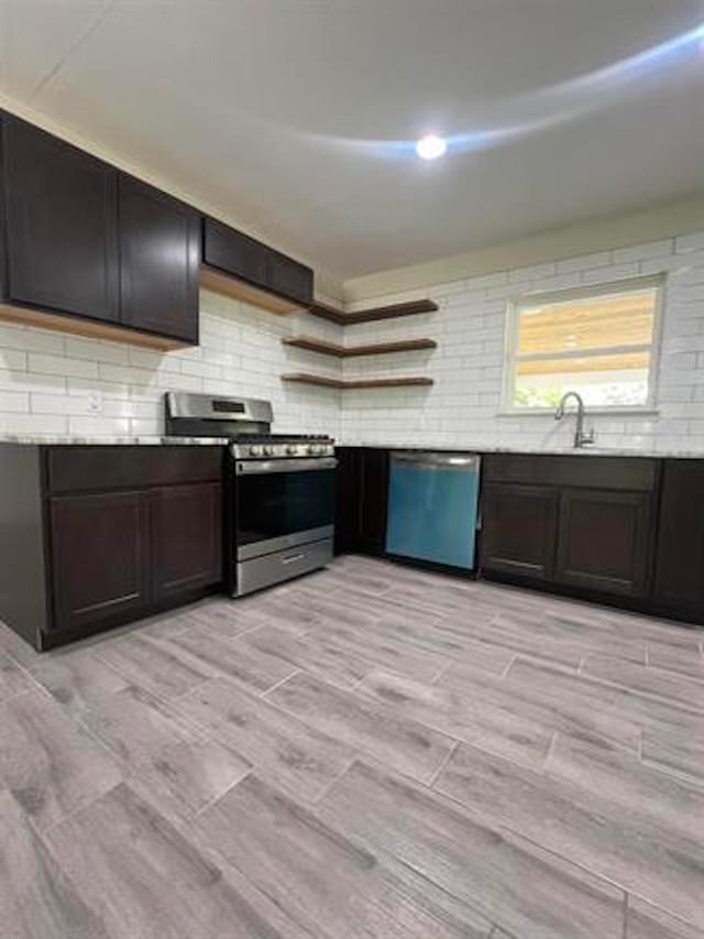 kitchen featuring dishwasher, gas stove, a sink, open shelves, and decorative backsplash