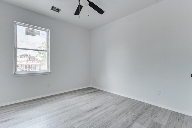spare room with a ceiling fan, baseboards, light wood finished floors, and visible vents