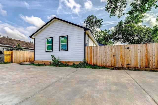 view of home's exterior with a patio and fence