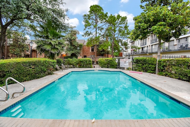 community pool with fence and a residential view