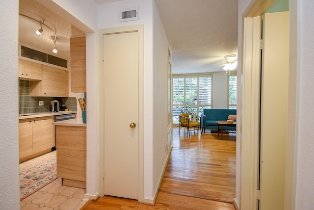 hallway featuring visible vents and light wood-style flooring