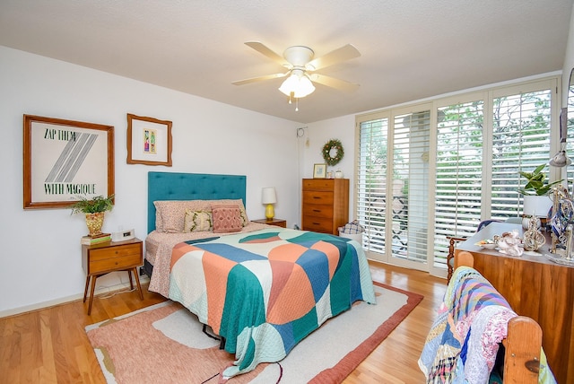 bedroom featuring baseboards, ceiling fan, access to exterior, and wood finished floors