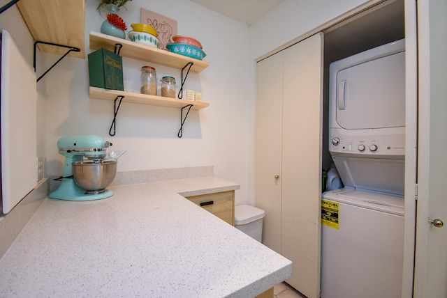 clothes washing area featuring laundry area and stacked washer and dryer