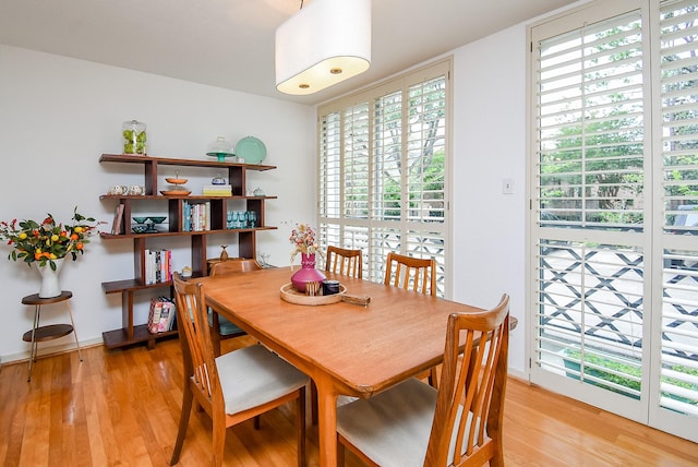 dining area featuring light wood-type flooring and plenty of natural light