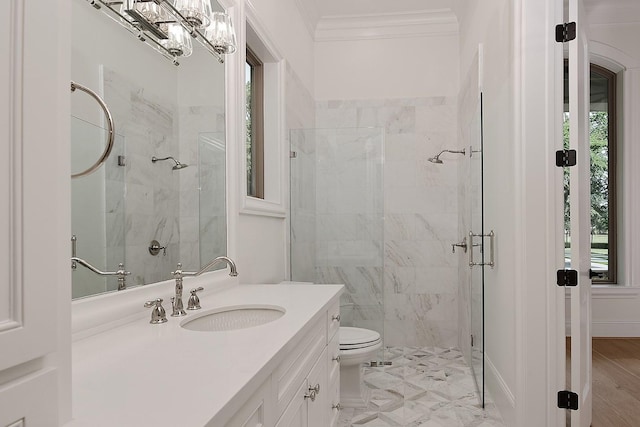 bathroom with crown molding, toilet, a shower stall, and vanity