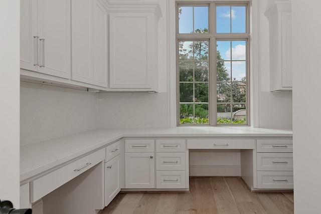 unfurnished office with built in study area and light wood-style flooring