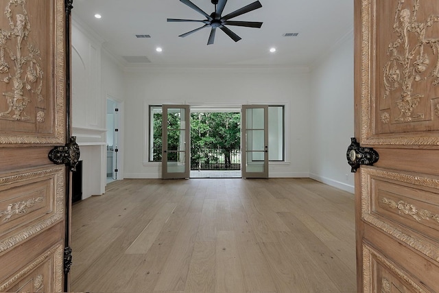 living area featuring baseboards, ceiling fan, visible vents, crown molding, and light wood-style floors