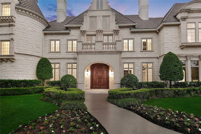 view of front facade with a front lawn and a balcony