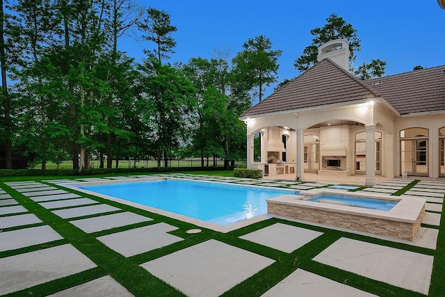 view of pool featuring an in-ground hot tub, a patio, an outdoor fireplace, and fence