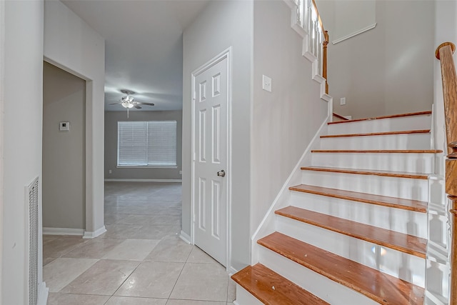 staircase with tile patterned flooring, baseboards, and a ceiling fan