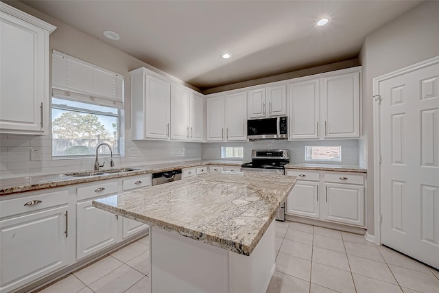 kitchen featuring white cabinetry, appliances with stainless steel finishes, light tile patterned flooring, and a sink