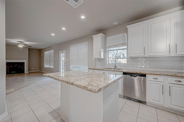 kitchen featuring a center island, a sink, stainless steel dishwasher, visible vents, and light tile patterned flooring