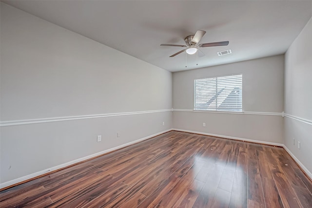 spare room with a ceiling fan, baseboards, visible vents, and wood finished floors