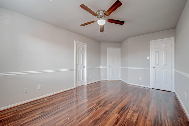 empty room featuring a ceiling fan, baseboards, and wood finished floors