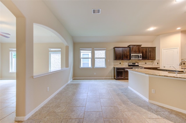 22526 Forbes Field Trl, Spring, TX 77389 - kitchen featuring stainless steel appliances, tasteful backsplash, visible vents, dark brown cabinetry, and light stone countertops