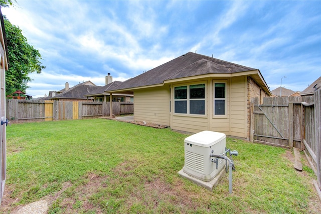22526 Forbes Field Trl, Spring, TX 77389 - back of house featuring a fenced backyard, a shingled roof, and a lawn