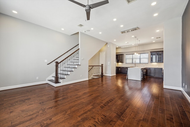 unfurnished living room featuring a ceiling fan, baseboards, recessed lighting, and dark wood-type flooring