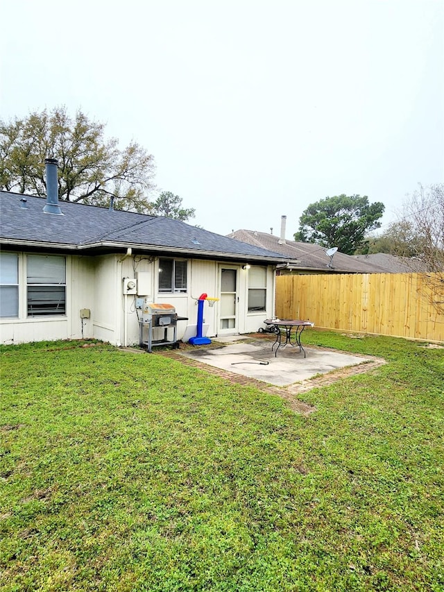 back of property with a yard, a patio area, and fence
