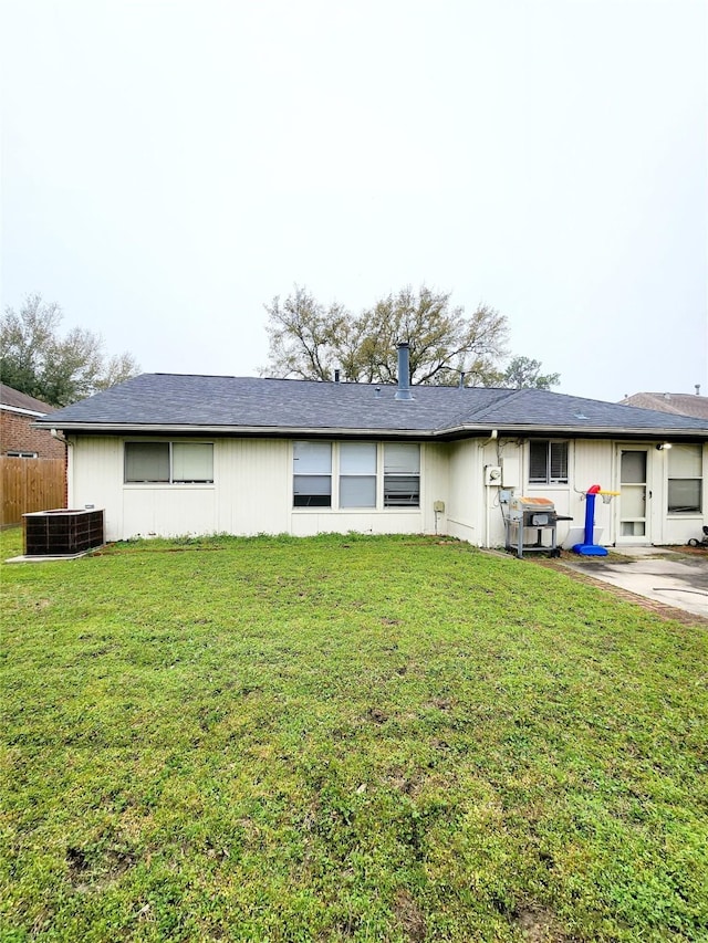 back of house featuring a lawn, cooling unit, and fence