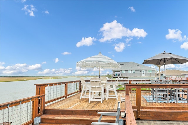 dock area featuring outdoor dining area and a deck with water view