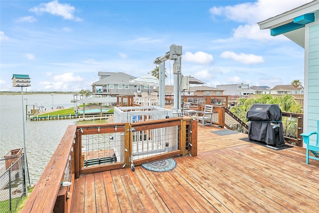 wooden terrace with a water view, a grill, and a residential view