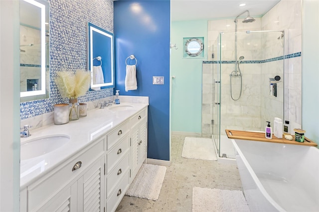 bathroom featuring a shower stall, baseboards, a soaking tub, and a sink