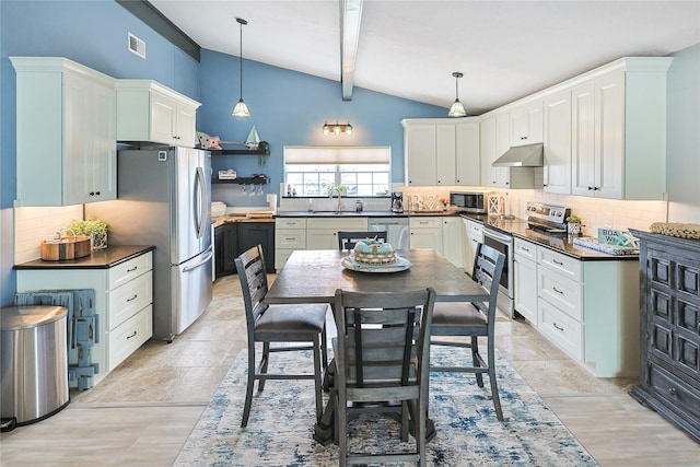 kitchen with under cabinet range hood, a sink, dark countertops, stainless steel appliances, and vaulted ceiling with beams