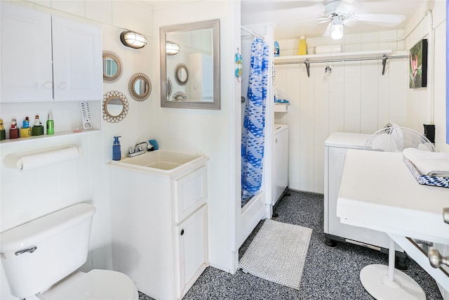 bathroom featuring toilet, washer and dryer, a sink, and a shower stall
