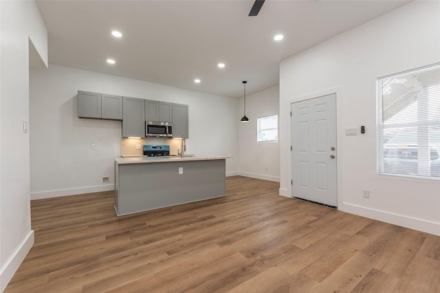 kitchen with stainless steel appliances, gray cabinetry, light countertops, and recessed lighting