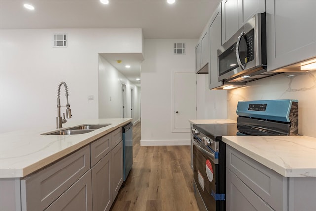 kitchen featuring gray cabinetry, appliances with stainless steel finishes, visible vents, and a sink