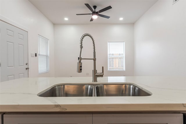 details with recessed lighting, light stone countertops, ceiling fan, and a sink