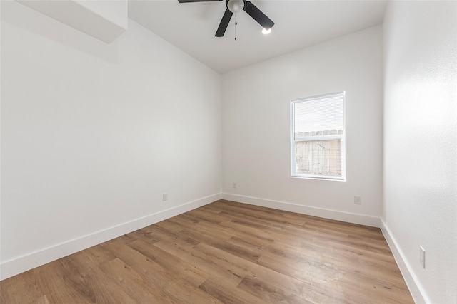 spare room featuring light wood-type flooring, baseboards, a ceiling fan, and lofted ceiling