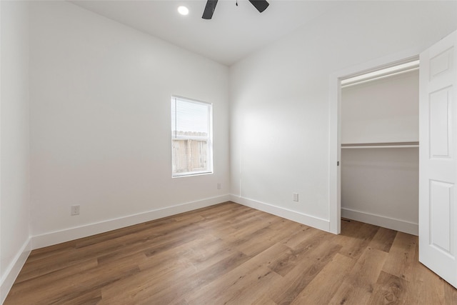 unfurnished bedroom featuring a closet, light wood-style floors, and baseboards