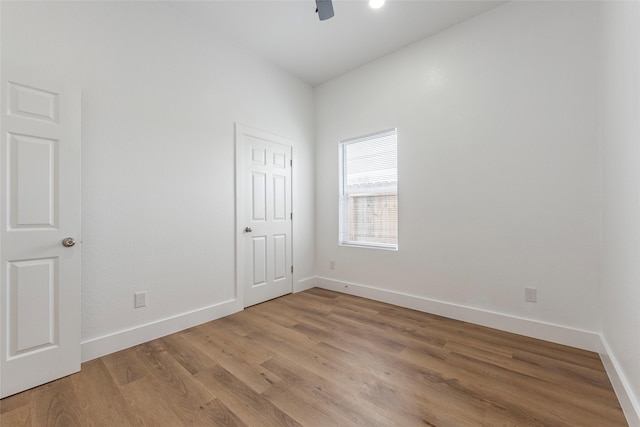 empty room with light wood finished floors, baseboards, and ceiling fan