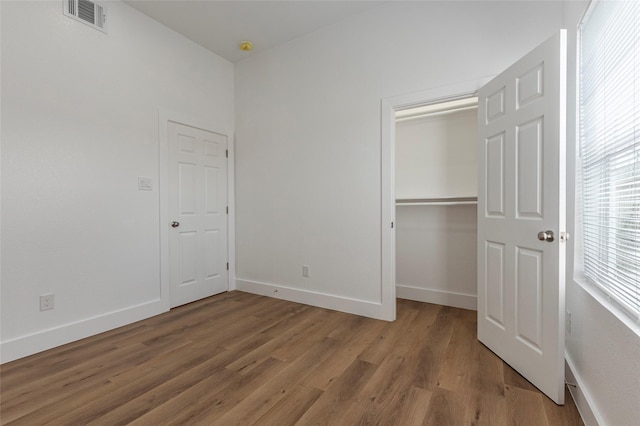 unfurnished bedroom with baseboards, light wood-style flooring, and visible vents