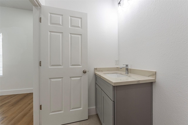 bathroom with vanity, baseboards, and wood finished floors