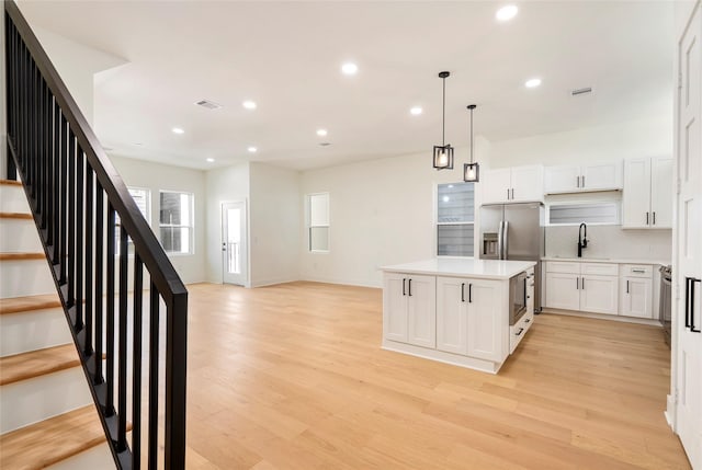 407 Grove St Unit B, Houston, TX 77020 - kitchen featuring light wood finished floors, light countertops, backsplash, a kitchen island, and recessed lighting