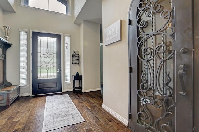 entrance foyer with healthy amount of natural light, dark wood-type flooring, baseboards, and arched walkways