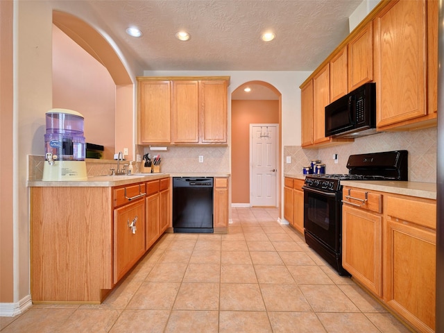 23623 Breckenridge Forest Dr, Spring, TX 77373 - kitchen with arched walkways, black appliances, light countertops, and a sink