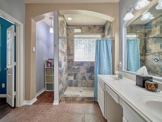 23623 Breckenridge Forest Dr, Spring, TX 77373 - full bathroom featuring double vanity, baseboards, a tile shower, and a sink