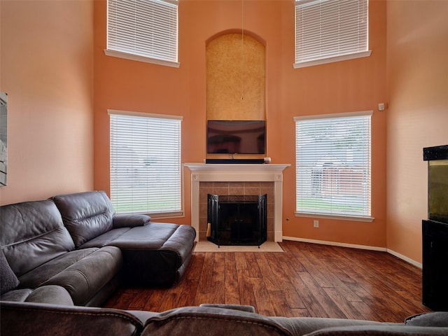 23623 Breckenridge Forest Dr, Spring, TX 77373 - living area with a tile fireplace, baseboards, a towering ceiling, and hardwood / wood-style floors
