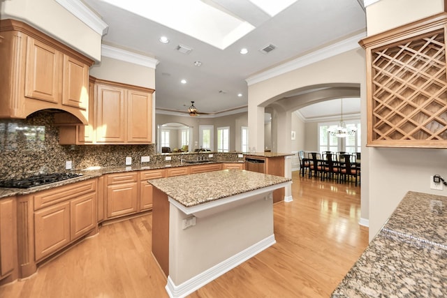 3818 Rose Grove Ln, Katy, TX 77494 - kitchen with black gas stovetop, arched walkways, ornamental molding, a peninsula, and light wood-style floors