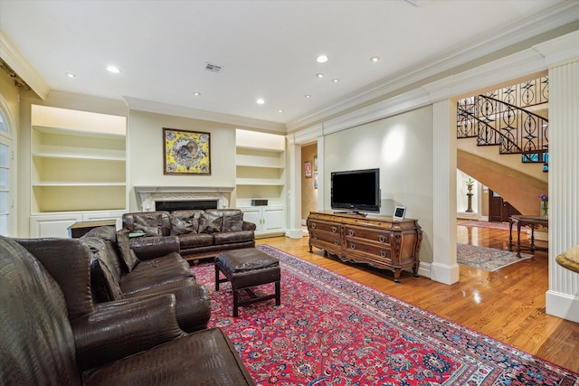 8722 Stable Crest Blvd, Houston, TX 77024 - living room featuring crown molding, built in shelves, stairs, wood finished floors, and a fireplace