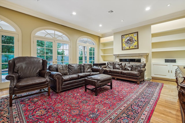 8722 Stable Crest Blvd, Houston, TX 77024 - living area featuring crown molding, light wood-type flooring, built in shelves, a high end fireplace, and recessed lighting