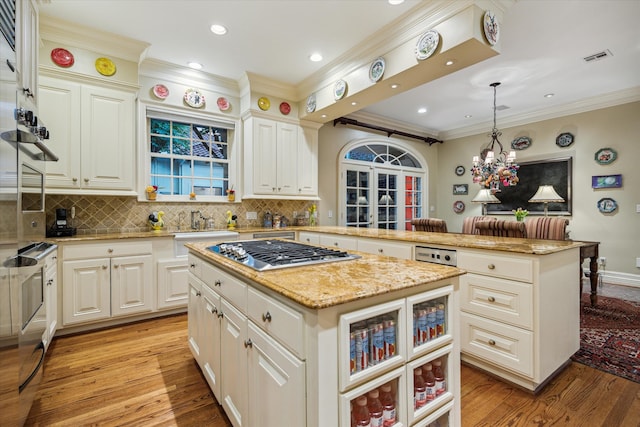 8722 Stable Crest Blvd, Houston, TX 77024 - kitchen featuring stainless steel gas cooktop, a kitchen island, light wood-type flooring, a peninsula, and decorative backsplash