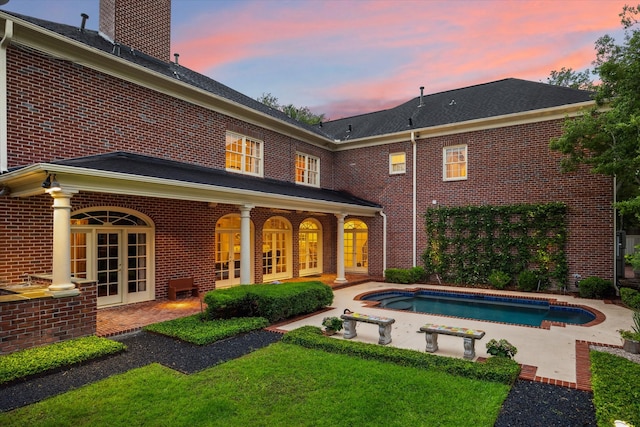 8722 Stable Crest Blvd, Houston, TX 77024 - rear view of house with brick siding, french doors, an outdoor pool, and a chimney